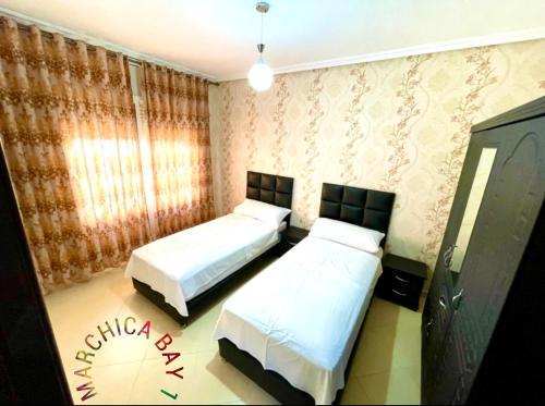 a bedroom with two beds and a window at Marchica Bay 1 holiday Apartment in Nador