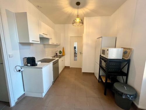 une cuisine avec un évier et un micro-ondes dans l'établissement Charmant T3 au cœur de la ville, à Marseille