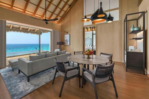 a living room with a table and a couch at JW Marriott Maldives Kaafu Atoll Island Resort in Male City