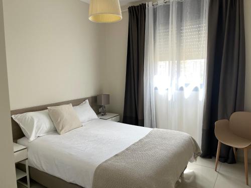 a bedroom with a white bed and a window at appartement privé exceptionnel in Netanya