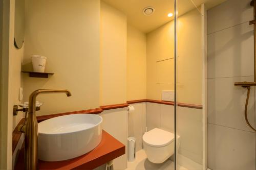 a bathroom with a sink and a toilet at The Queen's Twelve by Romy&Travis in Bruges