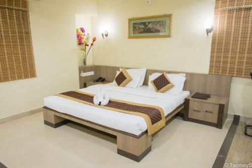 a bedroom with a large bed in a room at Vora Corporate Inn in Nagpur
