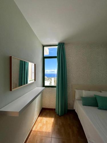 a bedroom with a bed and a large window at Apartamentos Halley in Puerto Rico de Gran Canaria