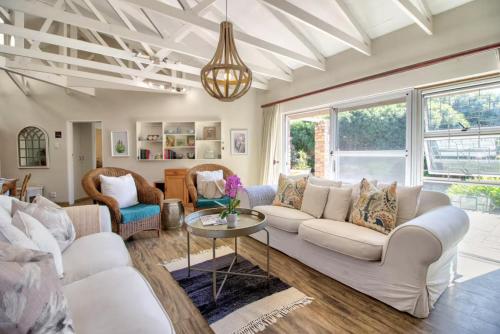 un soggiorno con un divano bianco e un tavolo di Miracle Villa a Kenton-on-Sea