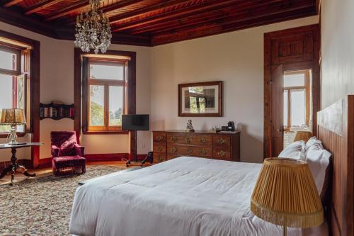 a bedroom with a bed and a table and a chair at Chalet Ficalho in Cascais