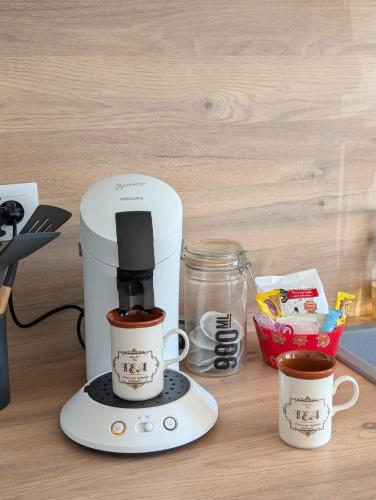 a coffee maker on a counter with two cups of coffee at Escapade poitevine - Maison climatisée avec 3 Ch - 4 min Futuroscope et Aquascope in Chasseneuil-du-Poitou
