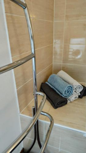 - une petite douche avec une serviette au sol dans l'établissement Le Cyprès en centre ville Bourg-Saint-Maurice, à Bourg-Saint-Maurice