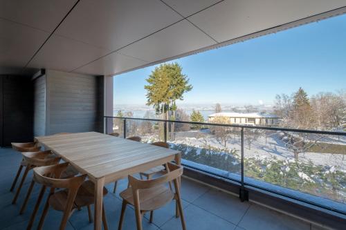 une salle à manger avec une table et des chaises et une grande fenêtre dans l'établissement Splendid T4 with Lake and Mountain View, à Évian-les-Bains
