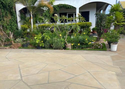 a patio in front of a house with plants at Appart Cozy Ivandry dans villa in Antananarivo