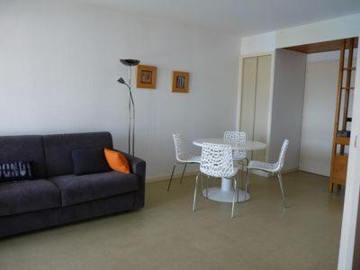 un salon avec un canapé, une table et des chaises dans l'établissement Vue sur Marina, à La Rochelle