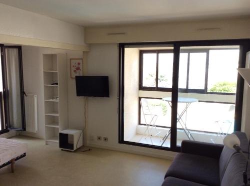 - un salon avec une grande fenêtre et une télévision dans l'établissement Vue sur Marina, à La Rochelle