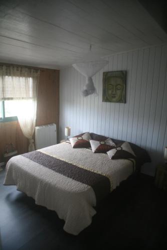 a bedroom with a bed and a picture of a head at Cabana do Pinheiral in Ponte da Barca