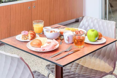 a table with breakfast foods and drinks on it at B&B Hotel Milano San Siro in Milan