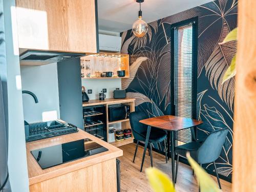 une petite cuisine avec une table et des chaises dans l'établissement Chalet insolite - SPA - Vue Pyrénées - Brasero, à Lasseube