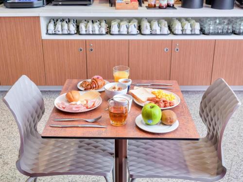 a table with plates of food and drinks on it at B&B Hotel Milano San Siro in Milan