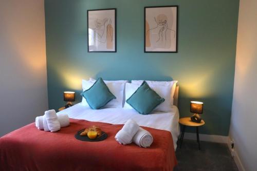 a bedroom with a bed with a red blanket and blue walls at Hope Cottage In Slough With Parking in Slough