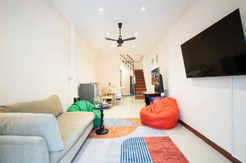 a living room with a couch and a flat screen tv at OH Homes - Samsen 12 in Bangkok