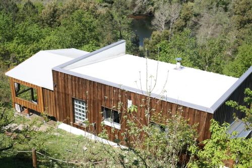 an aerial view of a wooden house with a white roof at Cabana do Pinheiral in Ponte da Barca