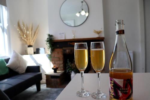 zwei Gläser Champagner auf einem Tisch im Wohnzimmer in der Unterkunft Hope Cottage In Slough With Parking in Slough