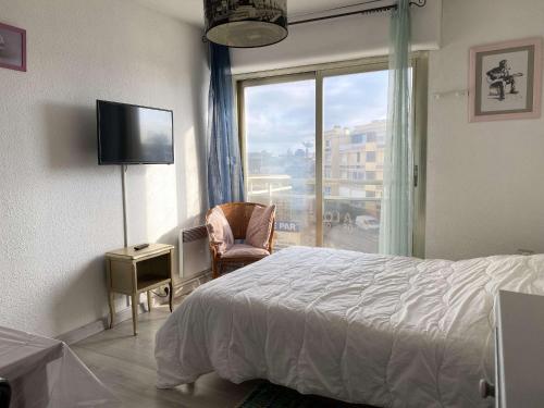 une chambre avec un lit, une fenêtre et une chaise dans l'établissement Studio cosy proche Thermes avec coin cuisine et vue sur étang - FR-1-553-237, à Balaruc-les-Bains