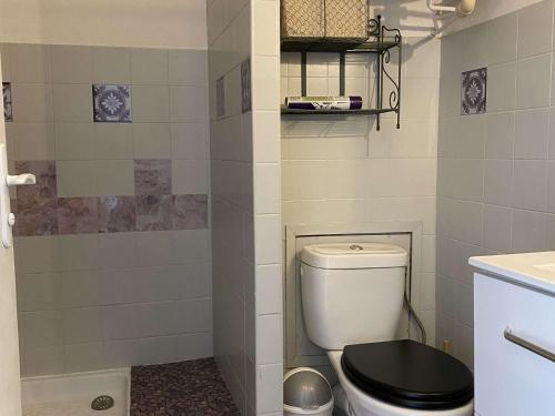 La salle de bains est pourvue de toilettes et d'un siège noir. dans l'établissement Studio cosy proche Thermes avec coin cuisine et vue sur étang - FR-1-553-237, à Balaruc-les-Bains