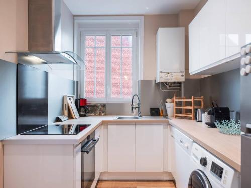 une cuisine blanche avec un évier et une cuisinière dans l'établissement Appartement familial au centre-ville avec balcon et WIFI - FR-1-821-7, à Le Touquet-Paris-Plage