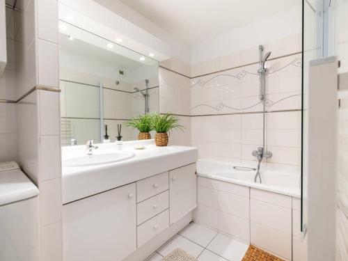 La salle de bains blanche est pourvue de 2 lavabos, d'une baignoire et d'une douche. dans l'établissement Appartement avec Terrasse et Parking au Touquet - FR-1-821-22, à Le Touquet-Paris-Plage