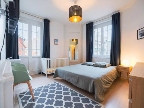 - une chambre avec un lit, un lit bébé et des fenêtres dans l'établissement Appartement familial au centre-ville avec balcon et WIFI - FR-1-821-7, à Le Touquet-Paris-Plage