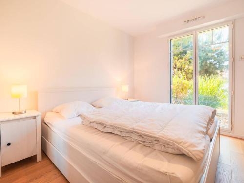 una camera da letto bianca con un letto e una finestra di Spacieux T2 au centre-ville avec grande pièce de vie - FR-1-821-29 a Le Touquet-Paris-Plage