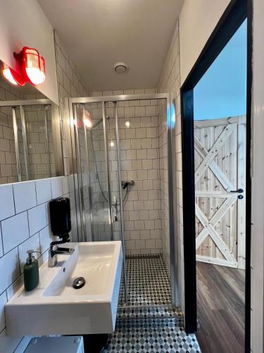 a bathroom with a white sink and a shower at Fabrika Doubice & Cifra Gallery in Doubice