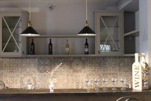 a kitchen counter with wine glasses and lights at Family Hotel Stumari in Tbilisi City