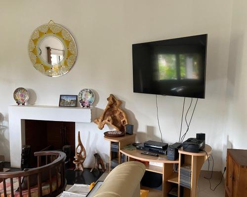 a living room with a couch and a tv on the wall at Appart Cozy Ivandry dans villa in Antananarivo