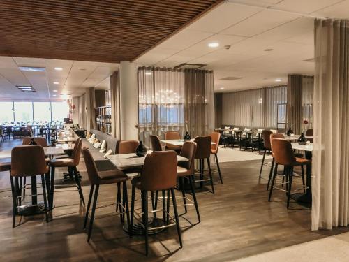 a restaurant with tables and chairs in a room at Vann Spa Hotell & Konferens in Brastad