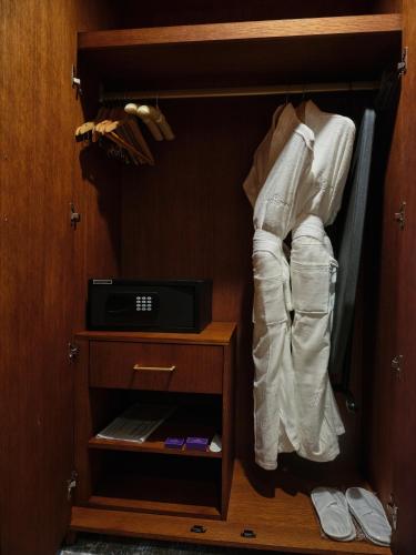 a closet with a drawer with a clock on it at The Central Point Hotel Baku in Baku