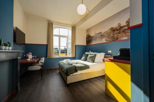 a bedroom with blue and yellow walls and a bed at The Queen's Twelve by Romy&Travis in Bruges
