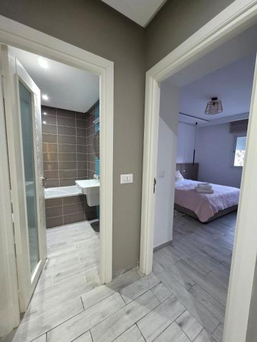 a room with a bathroom with a bed and a sink at appartement Sarra Mahdia in Hiboun