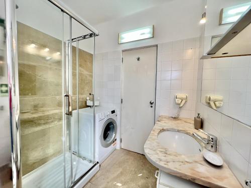a bathroom with a sink and a washing machine at Albufeira Skylight 2 by Homing in Vale de Pedras