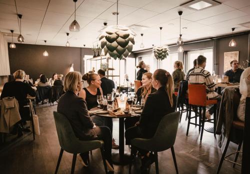 a group of people sitting at tables in a restaurant at Vann Spa Hotell & Konferens in Brastad