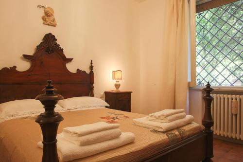 チェゼーナにあるLa Tana del Grillo Parlanteのタオルが敷かれたベッドのある寝室