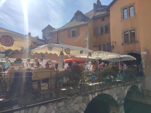 a group of people sitting at a table on a bridge at Chambre atypique 2 pers 200m du lac in Saint-Jorioz