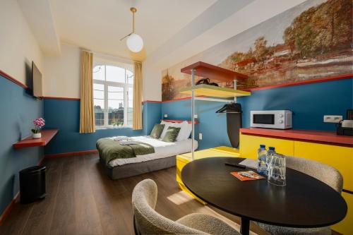 a room with a bed and a table and chairs at The Queen's Twelve by Romy&Travis in Bruges
