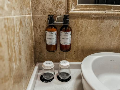 two bottles of alcohol sitting on a shelf next to a toilet at Osmanli Cappadocia Hotel in Goreme