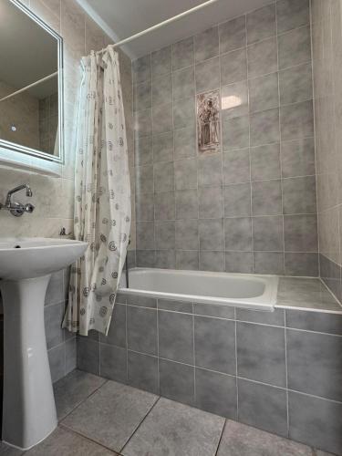a bathroom with a bath tub and a sink at Zakątek Bursztynowy in Łeba