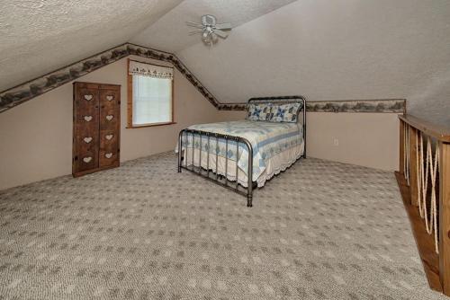 a bedroom with a bed and a dresser in a attic at Rustic Cabin with Jacuzzi Surrounded by Nature in Ohio in Rockbridge