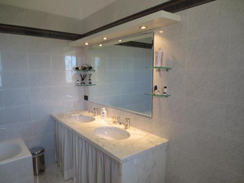 a bathroom with two sinks and a mirror at Villa Murgese in Noci