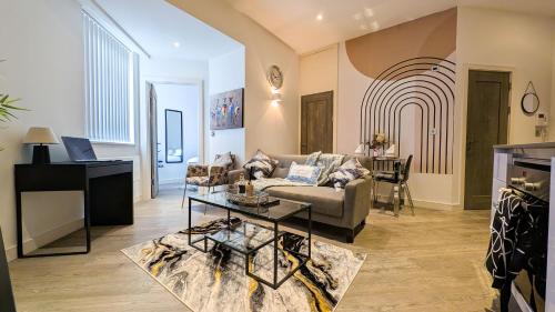 a living room with a couch and a table at Cozy Luxury Apartment In The Heart Of Slough -The Bethel Suite in Slough