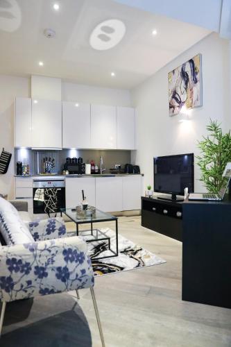 a living room with a couch and a table and a kitchen at Cozy Luxury Apartment In The Heart Of Slough -The Bethel Suite in Slough