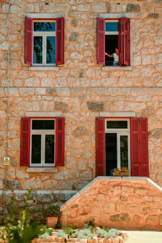 two windows with red shutters on a stone building at Chalet Ficalho in Cascais