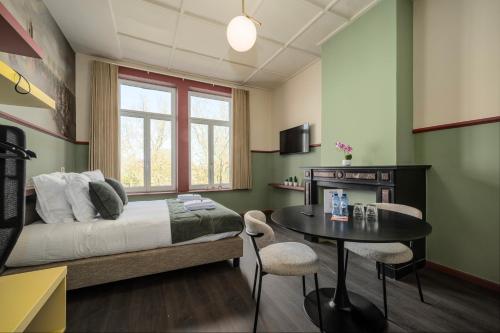 a bedroom with a bed and a table and chairs at The Queen's Twelve by Romy&Travis in Bruges