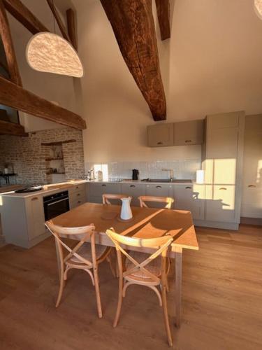a kitchen with a wooden table and chairs in a room at Au 8 à Meursault, Magnifique maison Bourguignonne au pied des vignes, jardin, places de parking privée in Meursault